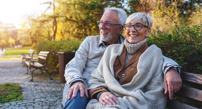 retired couple sitting on a bench