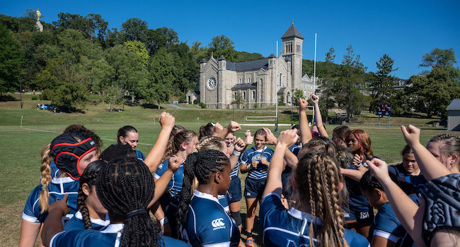 women's rugby team in a group on echo field